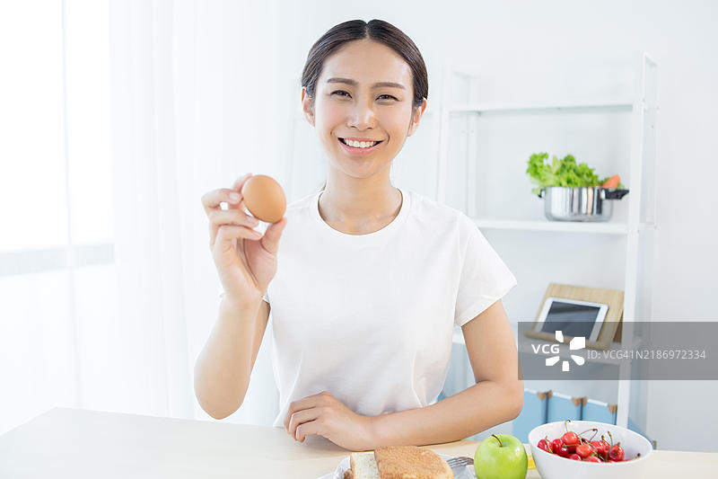 亚洲女性手中握着一个鸡蛋图片素材