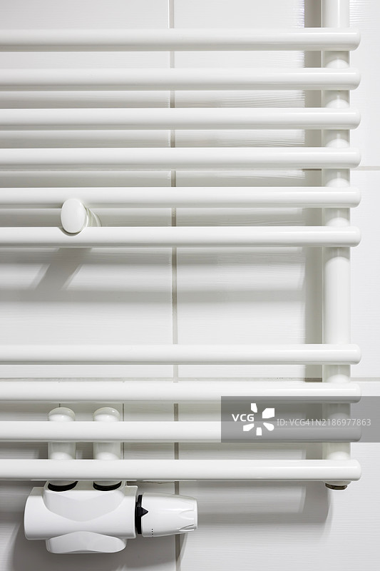 现代加热器和温控器安装在瓷砖墙上图片素材