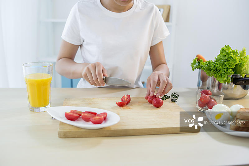 一位女性在厨房切番茄图片素材