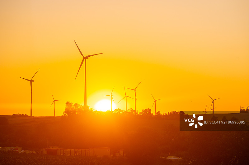 维也纳，奥地利 夕阳下田野上的风车剪影图片素材