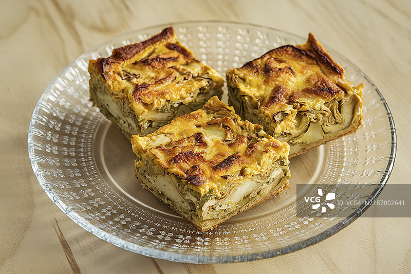 金棕色的菜肴，朝鲜蓟煎蛋饼，放在透明玻璃盘上图片素材