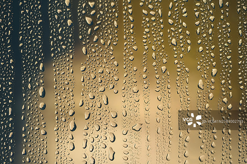 水滴在深黄色背景下的表面特写照片图片素材
