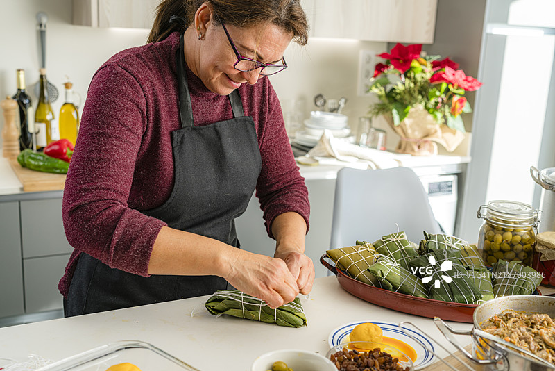 女人在包裹哈拉卡斯，委内瑞拉传统圣诞食品图片素材