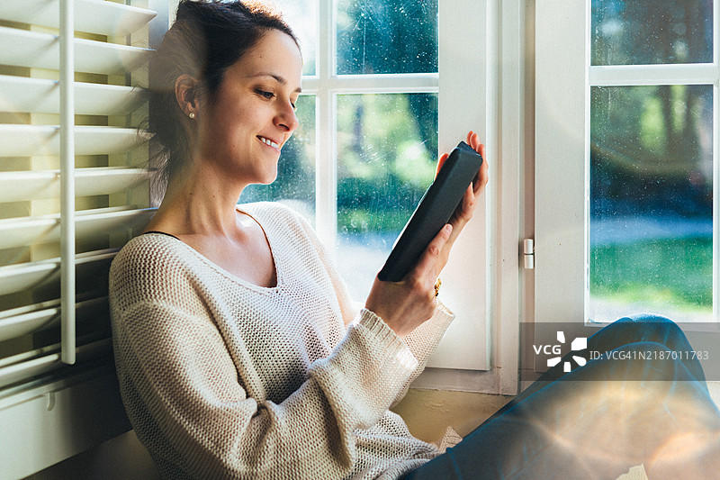 在家阅读电子书的女性图片素材