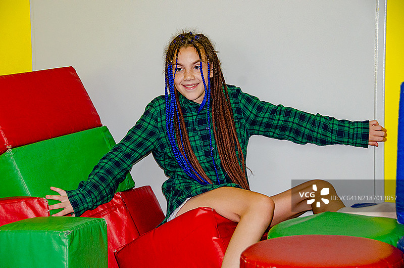 小女孩在室内游乐场玩彩色塑料形状图片素材