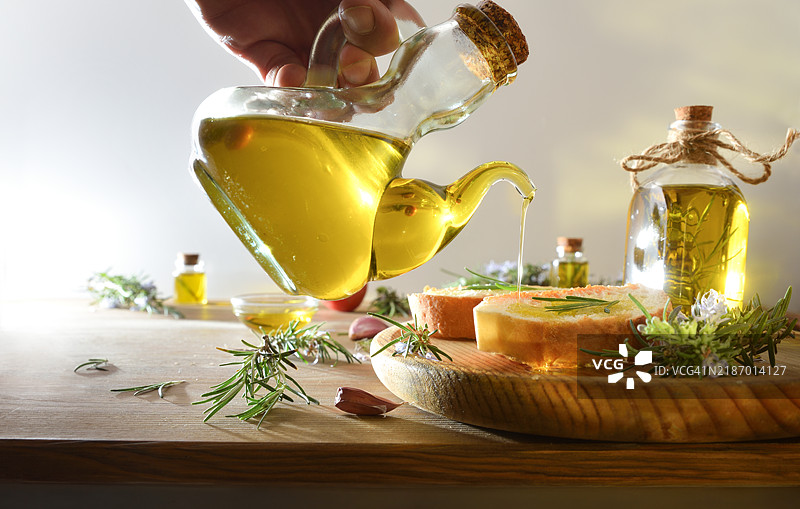 木桌上的迷迭香精油瓶和碗图片素材