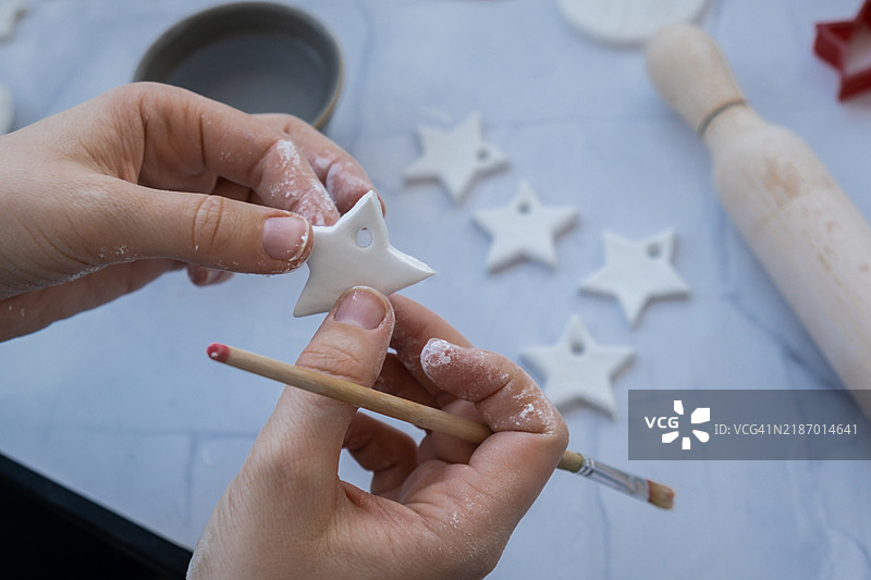 圣诞星创作者正在使用白色空气干燥粘土制作装饰品。图片素材