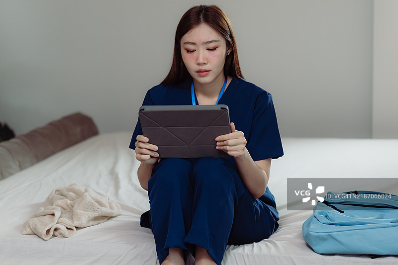 年轻的亚洲医疗专业人士在轻松的环境中使用平板电脑学习。图片素材