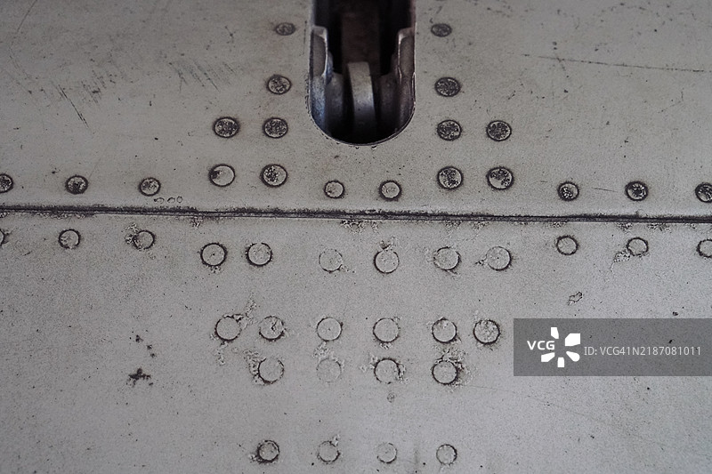 军用飞机机翼结构上的重金属铆钉特写镜头图片素材