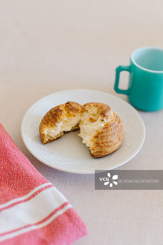 法式泡芙或奶油泡芙，搭配新鲜奶油，摆放在咖啡桌上图片素材