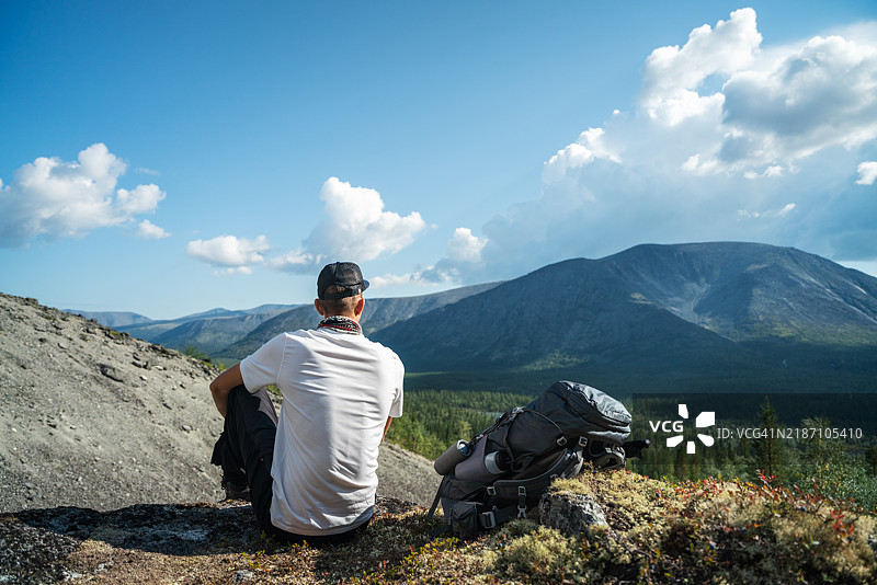 年轻男子在大自然中欣赏美丽的山景图片素材