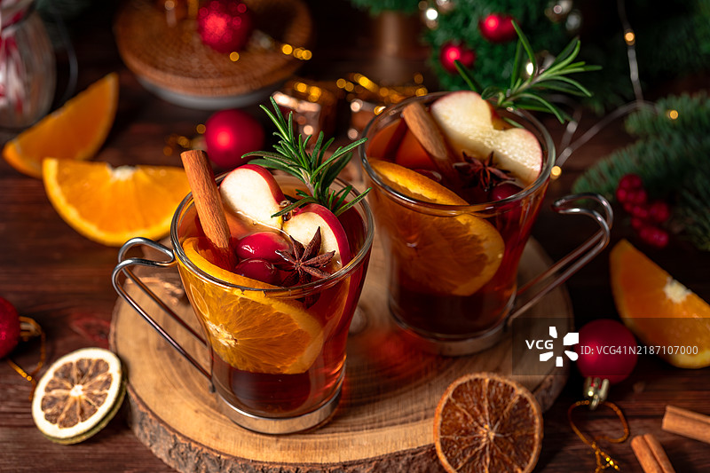 装饰有橙子、肉桂和冷杉树的圣诞热红酒放在木桌上图片素材