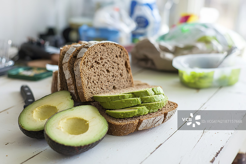 白色木桌上的棕色面包片配鳄梨图片素材