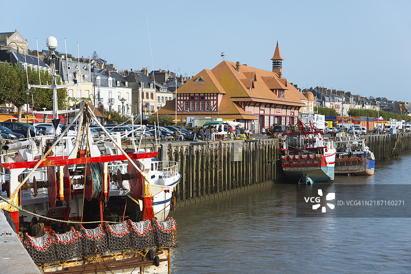 色彩斑斓的船只停靠在港口边缘,背景是一个历史悠久的海滨小镇,渔船,特鲁维尔-苏尔-梅,特鲁维尔,图克河,花卉海岸,昂弗勒尔-多维尔,利锡厄,卡尔瓦多斯,诺曼底,英吉利海峡,法国,欧洲图片素材