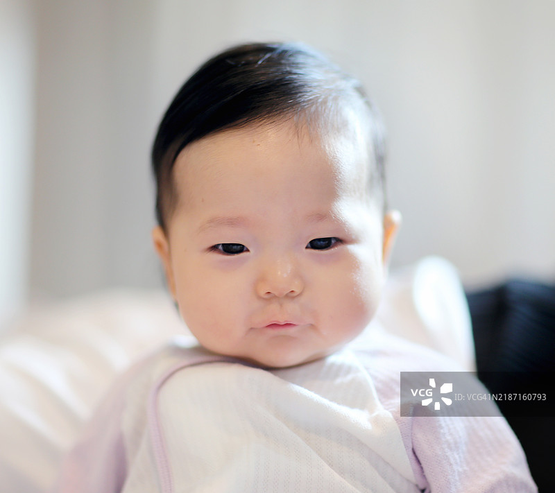 快乐的婴儿坐在床上图片素材