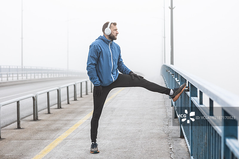 晨雾中伸展的跑者图片素材