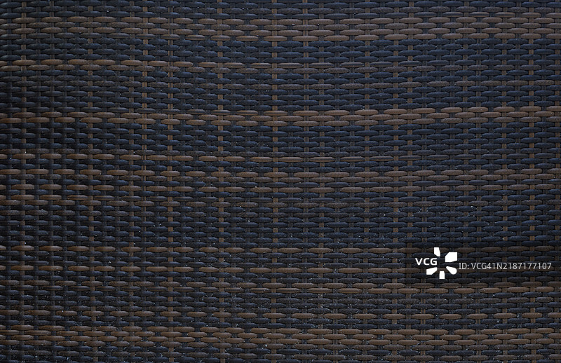 从上方俯视的深色编织物与一些沙子特写。图片素材