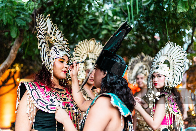 年轻女性在户外穿着阿兹特克服装准备表演图片素材