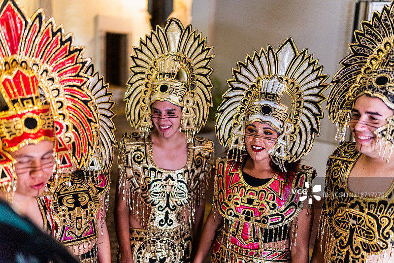 年轻朋友们穿着阿兹特克服装在户外交谈图片素材