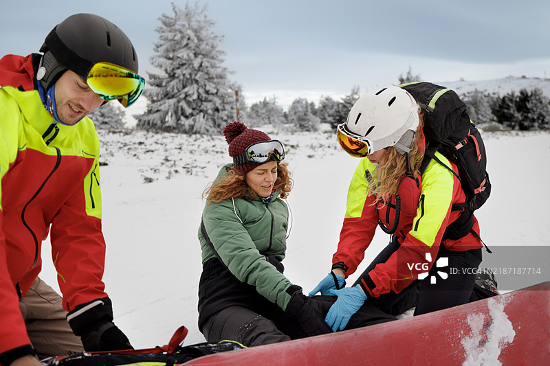 冬季救援服务在山顶帮助年轻女性图片素材