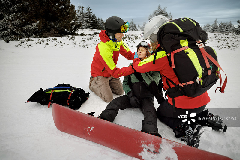 救援队为在滑雪时受伤的女性滑雪者戴上颈托图片素材