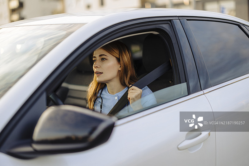 穿着医务制服的女性在车内系安全带图片素材