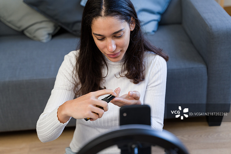 网红在录制美容教程时涂抹保湿霜图片素材