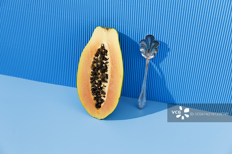 蓝色背景上的半个木瓜水果图片素材