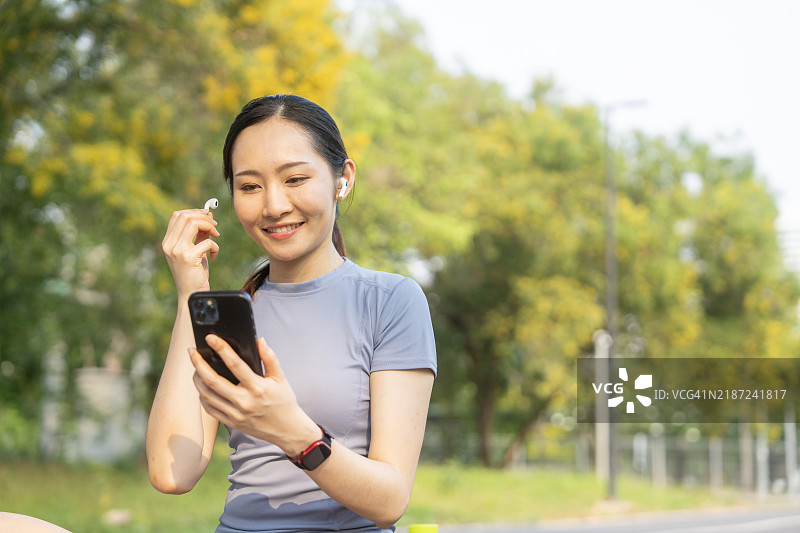 微笑的女性在户外享受无线耳机带来的音乐图片素材