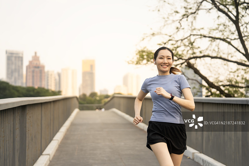 女性在城市桥上晨跑锻炼图片素材