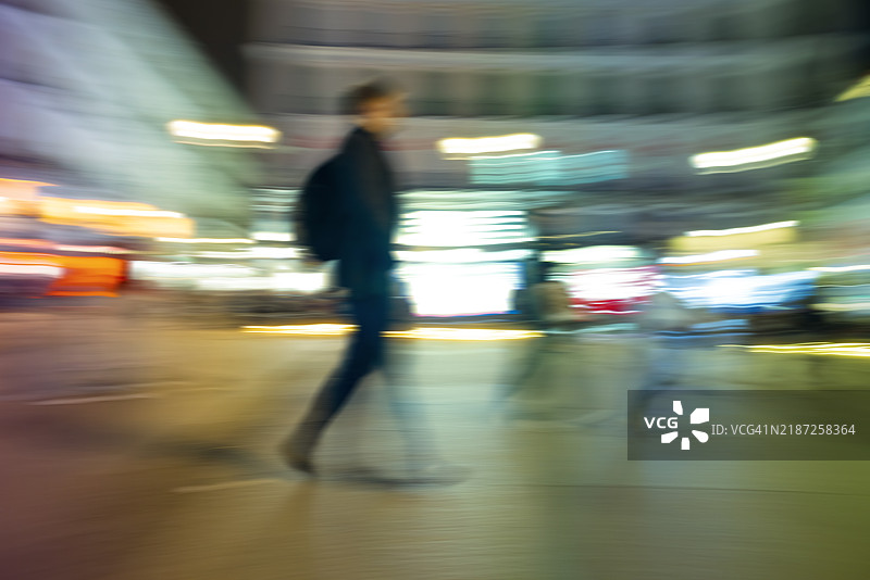 马德里夜晚行走的人们的长时间曝光照片。图片素材