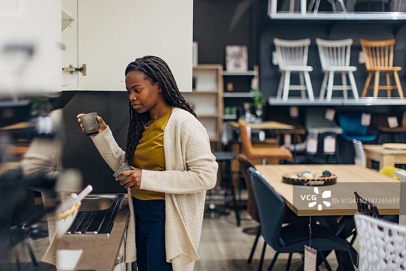 一位黑人女性正在百货商店寻找厨房用品图片素材