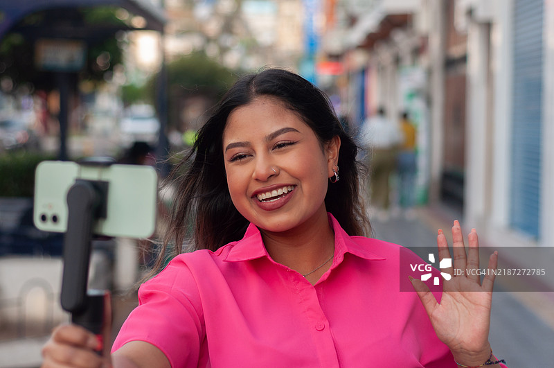 充满活力的年轻女性在户外进行视频博客，吸引观众，记录她的独自城市旅行。世界旅游日图片素材