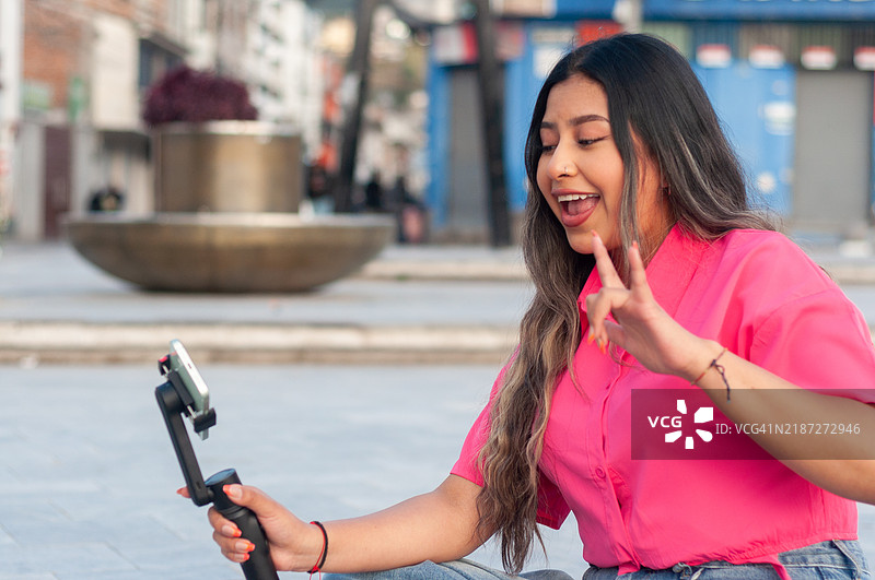 年轻女孩在现代城市环境中记录她的独自旅行冒险。世界旅游日图片素材