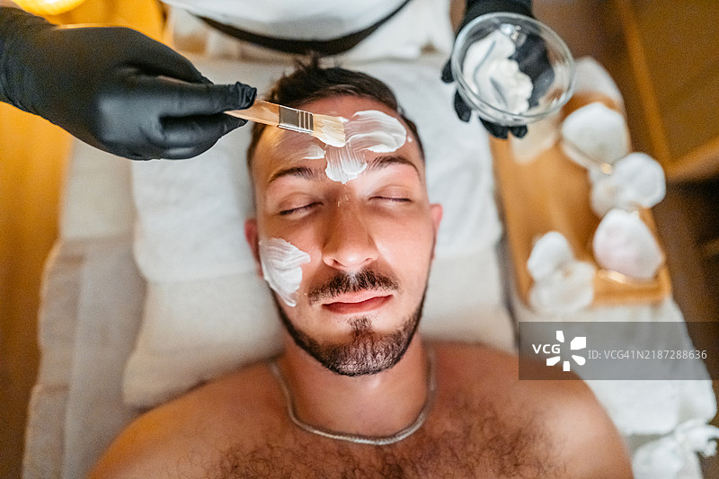 中年男子在水疗中心进行面部美容护理图片素材