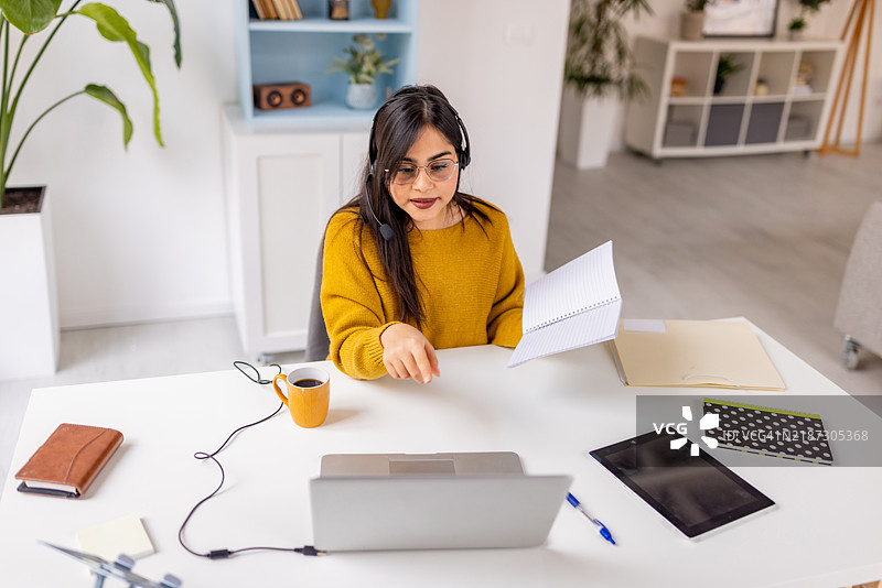 女性在家中参加在线会议时做笔记图片素材