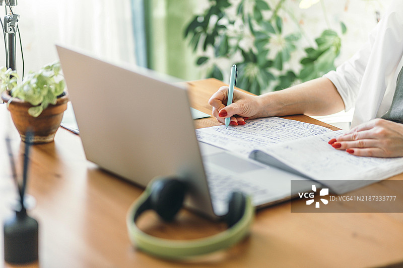 女性的手在桌子上使用笔记本电脑，适合远程学习的科技工作空间图片素材