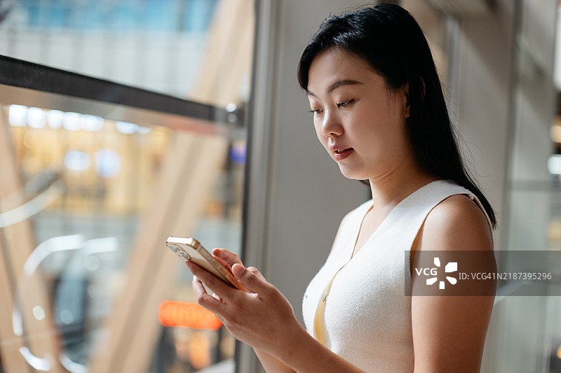 亚洲女商人在办公室使用智能手机图片素材