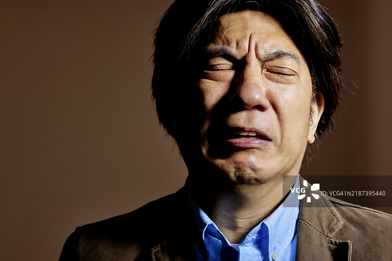 一个男人从愤怒和悲伤中走出来的肖像。图片素材