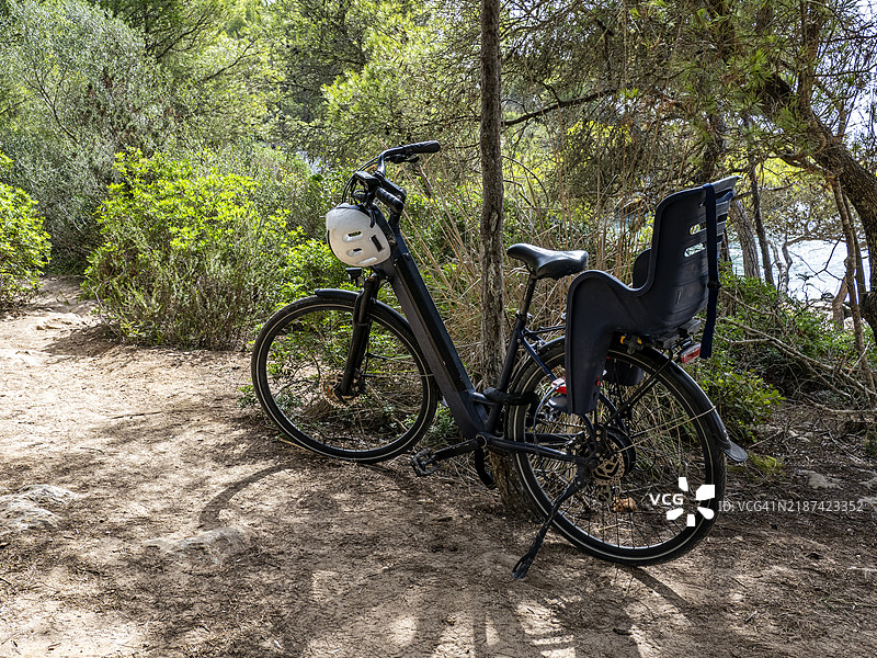 停在海边自然环境中的带婴儿座椅的自行车。图片素材