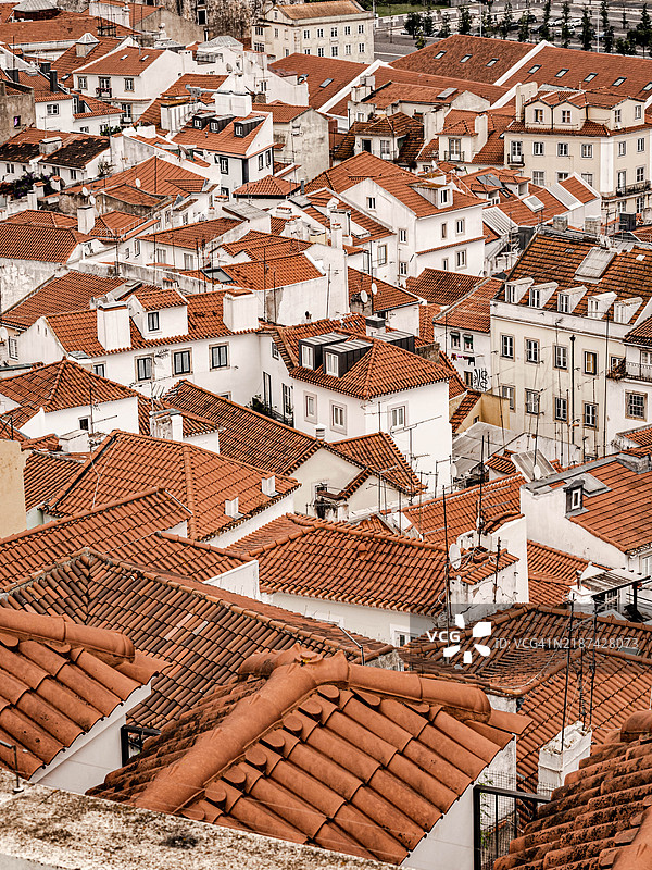 历史悠久的里斯本街区中，密集的红瓦屋顶和白墙建筑群。图片素材
