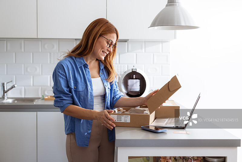 女人在家拆开快递包裹图片素材