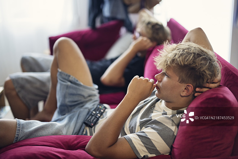 两个少年男孩一起享受观看电影的时光。图片素材