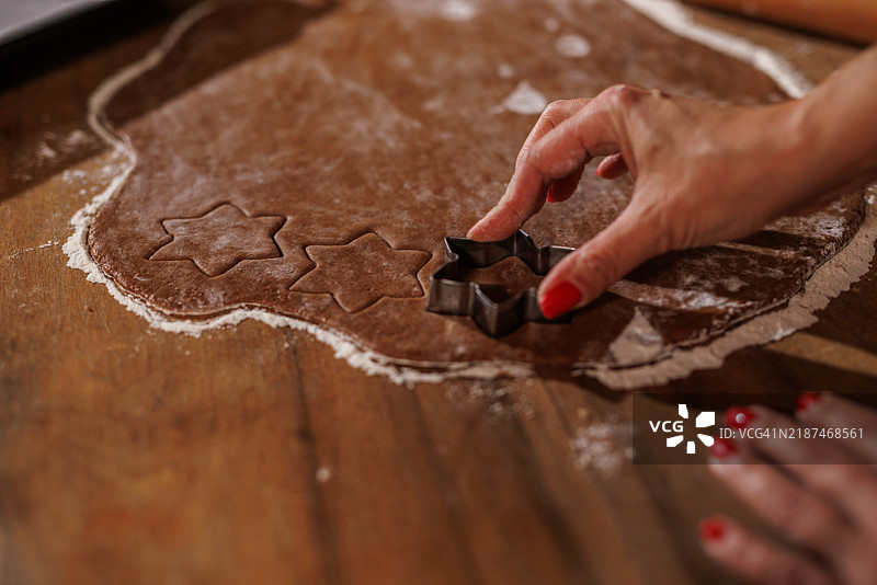 在木制厨房桌上用手塑形星形饼干面团图片素材