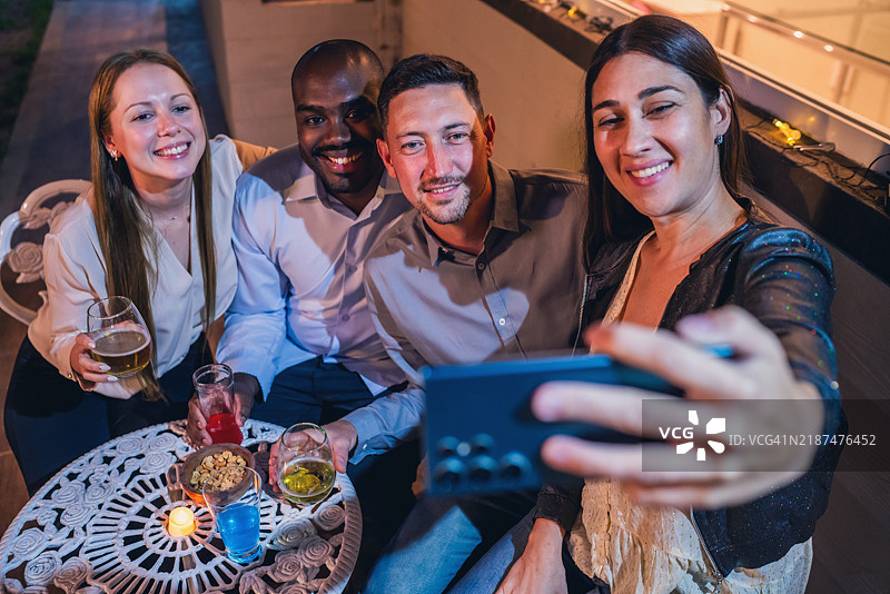 朋友们享受轻松的夜晚并拍自拍照图片素材