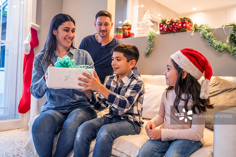 快乐的家庭在家中庆祝圣诞节并互换礼物图片素材