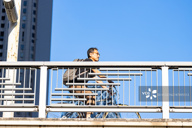 一位商人在城市中骑自行车出行工作。图片素材