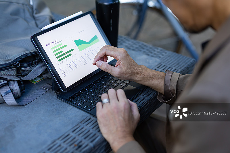 一名男性商务人士在公园骑自行车时使用数字设备。图片素材