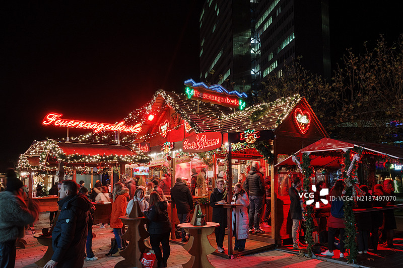 圣诞市场场景，多个明亮的摊位提供传统的火焰酒。图片素材