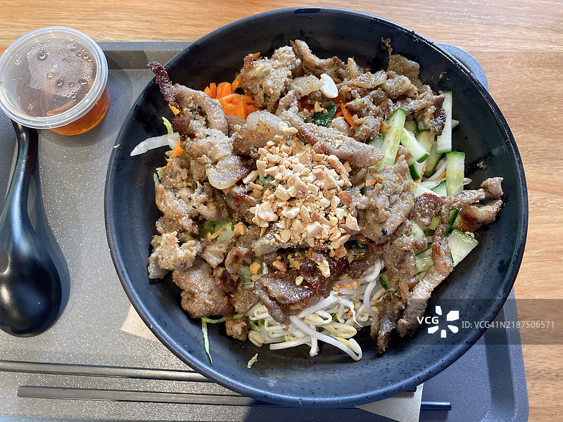 猪肉包（bún）温暖的米粉沙拉，配有胡萝卜丝、生菜、黄瓜、花生、豆芽、香菜和鱼露酱。图片素材